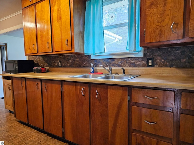 kitchen with sink, light parquet floors, decorative backsplash, and ornamental molding