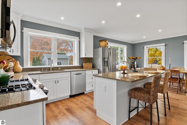 kitchen featuring sink, a kitchen island, white cabinets, and stainless steel appliances