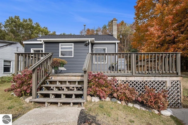 1219 Elm St, Frankfort, MI 49635 - back of property with a chimney and a deck