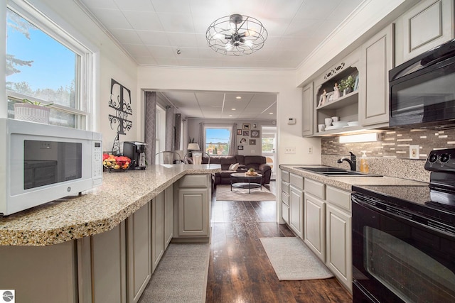 kitchen featuring dark wood-type flooring, light stone countertops, black appliances, decorative backsplash, and gray cabinetry