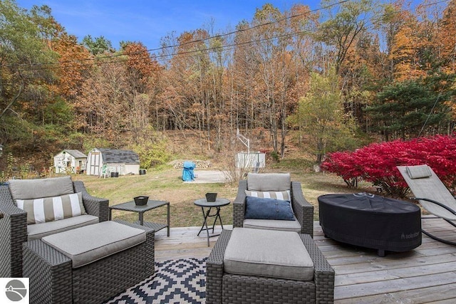 1219 Elm St, Frankfort, MI 49635 - wooden terrace with an outdoor hangout area, a storage unit, and an outbuilding