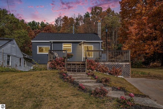 view of front of property featuring a deck and a lawn