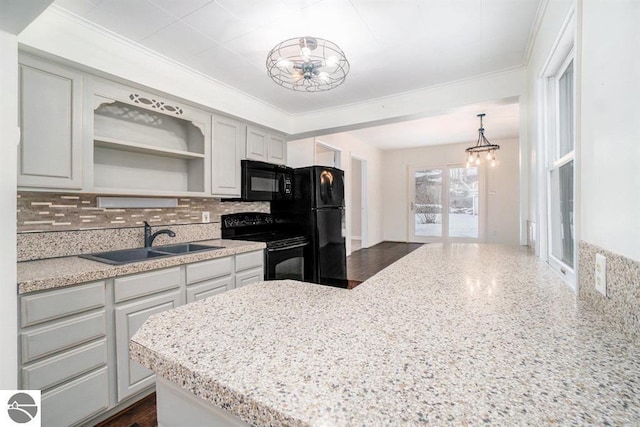 1219 Elm St, Frankfort, MI 49635 - kitchen with open shelves, a sink, black appliances, a chandelier, and backsplash