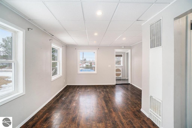 1219 Elm St, Frankfort, MI 49635 - empty room with hardwood / wood-style flooring, a drop ceiling, baseboards, a heating unit, and recessed lighting