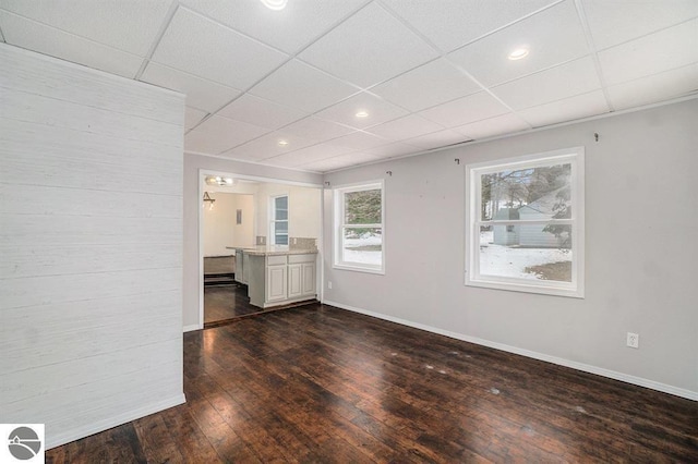 1219 Elm St, Frankfort, MI 49635 - interior space with baseboards, a drop ceiling, recessed lighting, and dark wood-style flooring