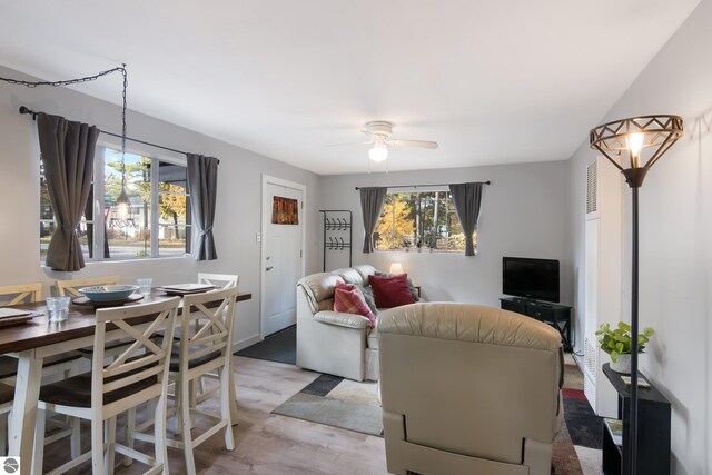 living room featuring light wood-style floors and a ceiling fan