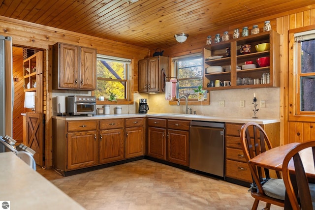 kitchen featuring sink, wood ceiling, stainless steel appliances, and wood walls