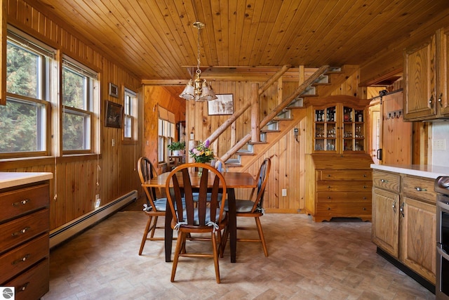 dining space featuring wood ceiling, wood walls, and baseboard heating