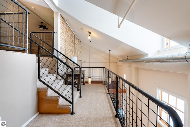 stairway featuring ceiling fan, carpet flooring, vaulted ceiling, and baseboards