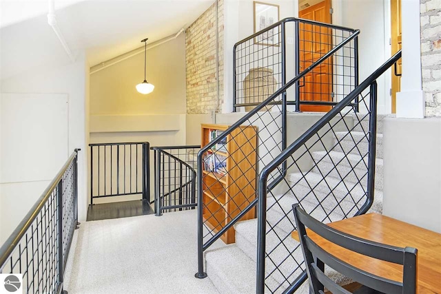 staircase with high vaulted ceiling and carpet