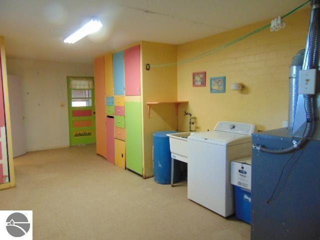 laundry room with light colored carpet and washing machine and clothes dryer