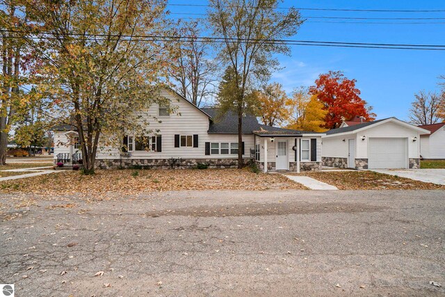 view of front of home with an attached garage, stone siding, and concrete driveway