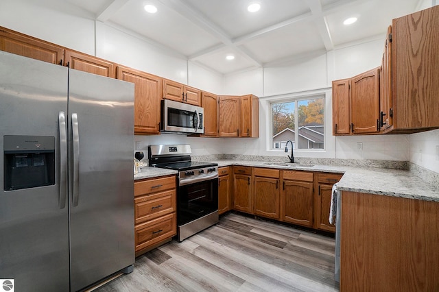 kitchen featuring coffered ceiling, beamed ceiling, sink, appliances with stainless steel finishes, and light hardwood / wood-style floors