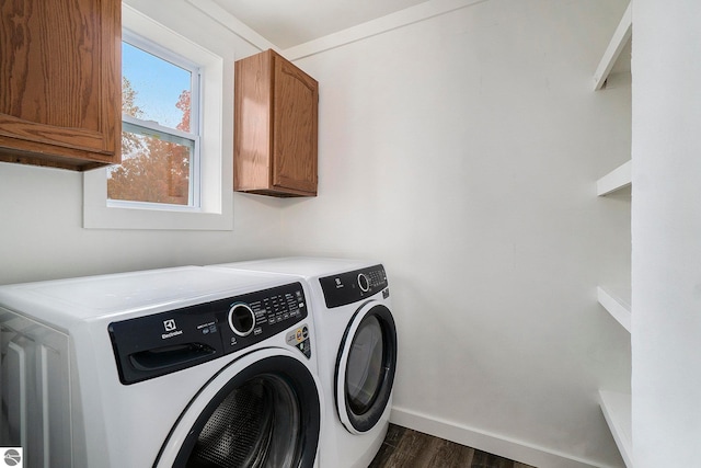 washroom with baseboards, washer and clothes dryer, dark wood finished floors, and cabinet space
