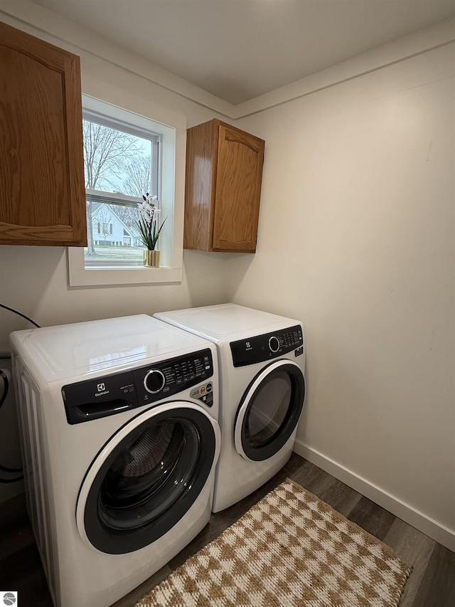clothes washing area featuring washer and dryer, baseboards, cabinet space, and dark wood-style floors