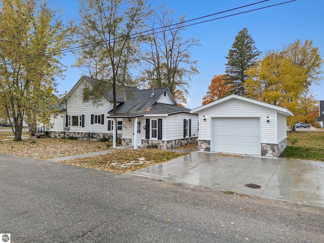 view of front of home featuring driveway, stone siding, and a garage
