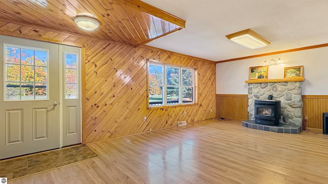 interior space with wood walls, a wood stove, and a wealth of natural light