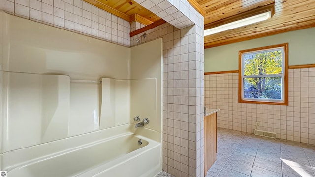 bathroom with shower / tub combination, wooden ceiling, tile patterned floors, and tile walls