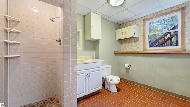 bathroom featuring vanity, a shower, a paneled ceiling, and toilet