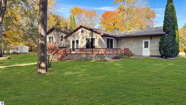 ranch-style house featuring a front lawn and a wooden deck