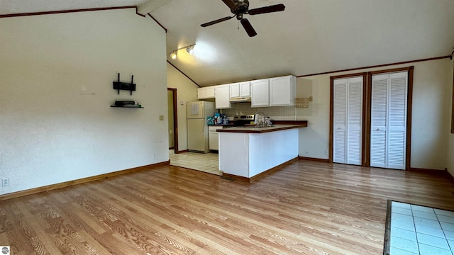 kitchen with white fridge, light hardwood / wood-style floors, kitchen peninsula, and white cabinets