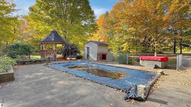 view of pool with a gazebo, a shed, and a patio area