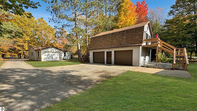 view of side of property featuring a garage and a lawn