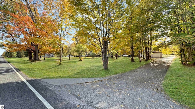 view of community featuring a lawn and an outbuilding