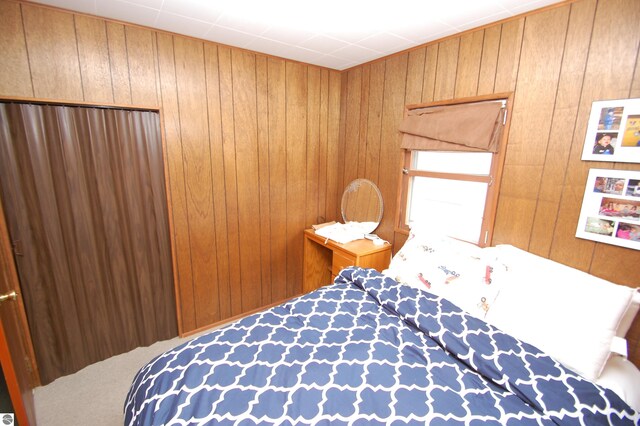 bedroom with wood walls and carpet floors