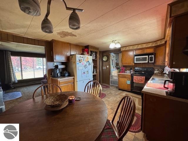 dining space featuring sink and wooden walls