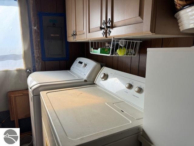 laundry area with cabinets, electric panel, and washing machine and dryer