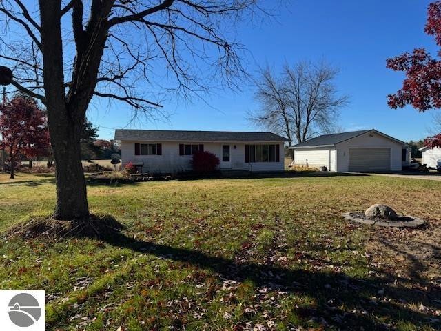 ranch-style home with a front lawn, an outbuilding, and a garage