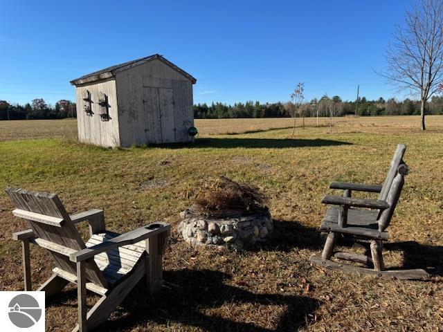 exterior space featuring a rural view, a yard, and a storage shed