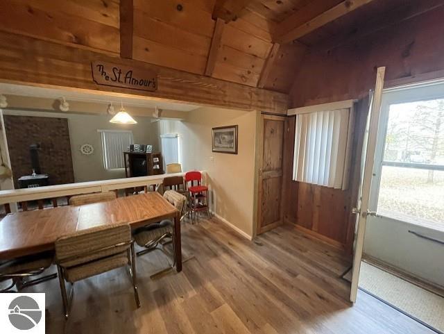 bar featuring vaulted ceiling with beams, wood ceiling, hardwood / wood-style floors, and pendant lighting