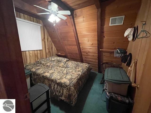 bedroom with dark carpet, wooden walls, wood ceiling, and ceiling fan