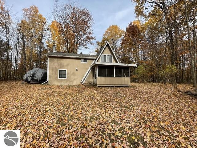 back of property with a sunroom