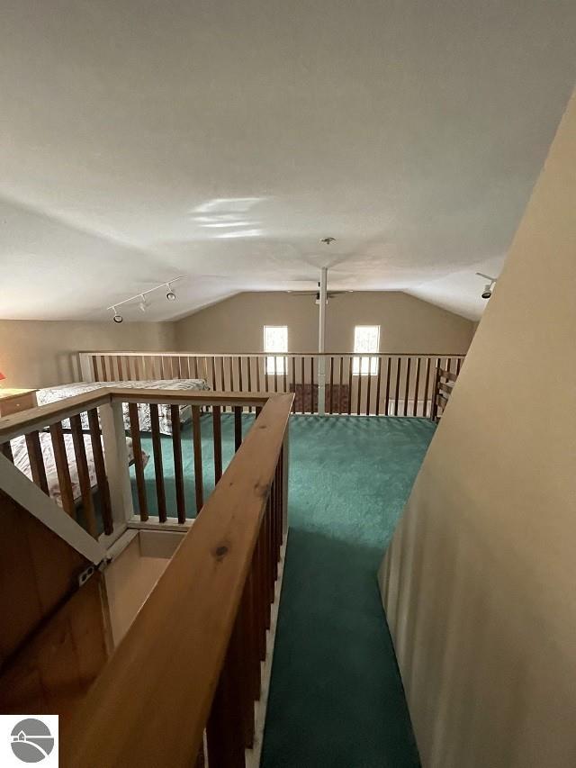 hallway featuring lofted ceiling and carpet floors