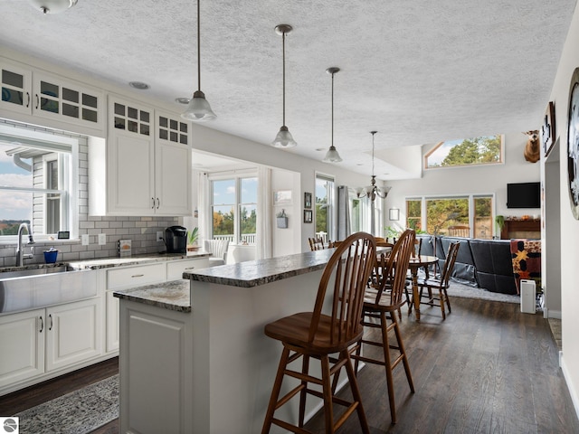 kitchen with a healthy amount of sunlight, a center island, and white cabinets