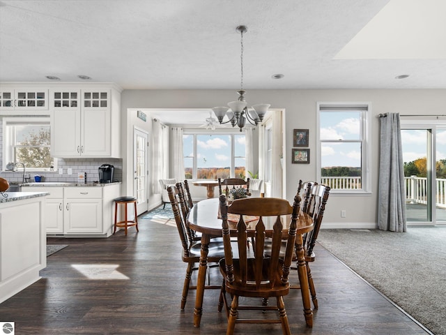 dining room featuring a notable chandelier, a textured ceiling, and dark wood-type flooring