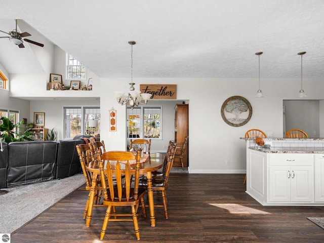 dining space featuring dark wood-type flooring, high vaulted ceiling, a textured ceiling, and ceiling fan with notable chandelier