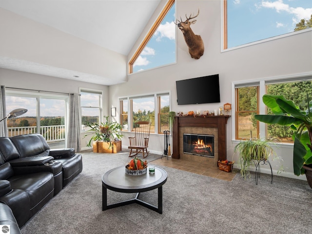 living room with a tile fireplace, carpet, and high vaulted ceiling