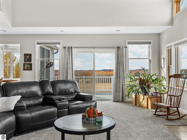 living room with light tile patterned floors, a wealth of natural light, and a high ceiling