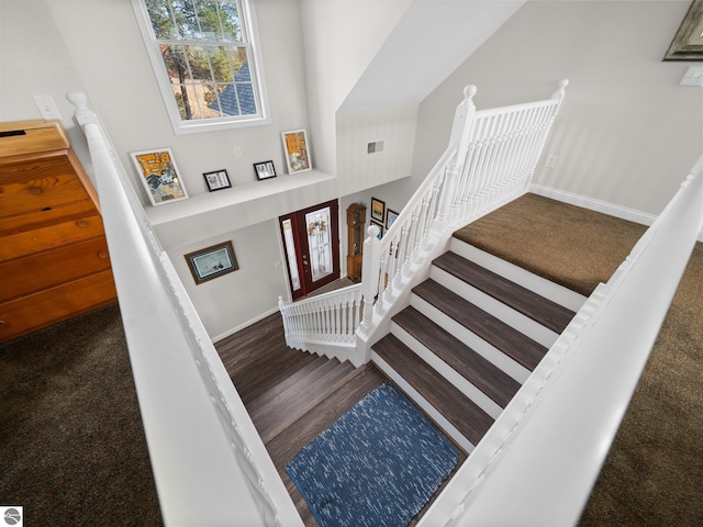 stairs featuring high vaulted ceiling and hardwood / wood-style flooring