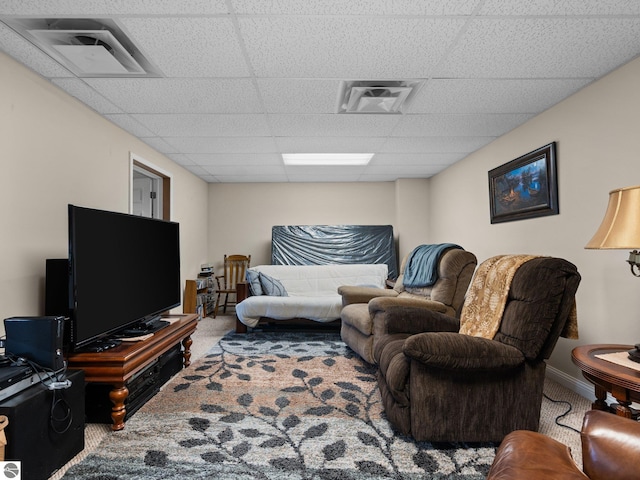 living room featuring carpet floors and a paneled ceiling