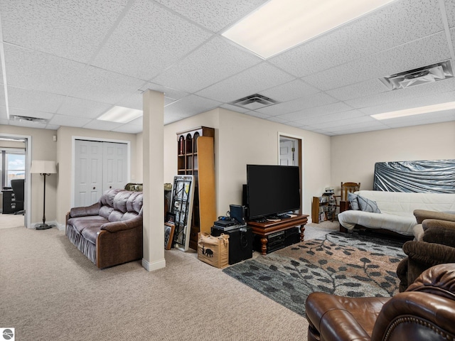 carpeted living room featuring a paneled ceiling