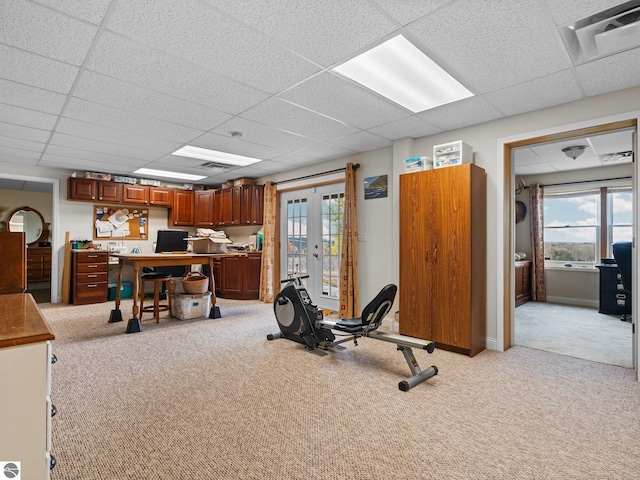 workout room with french doors, light carpet, a drop ceiling, and a wealth of natural light