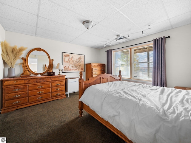 carpeted bedroom with a drop ceiling