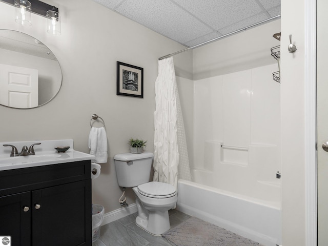 full bathroom featuring tile patterned floors, toilet, shower / bath combination with curtain, a drop ceiling, and vanity