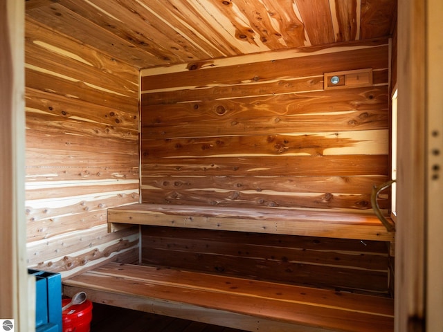 view of sauna with wooden ceiling and wooden walls