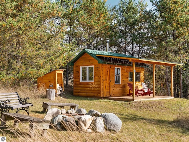 exterior space with a patio area, a lawn, and an outbuilding